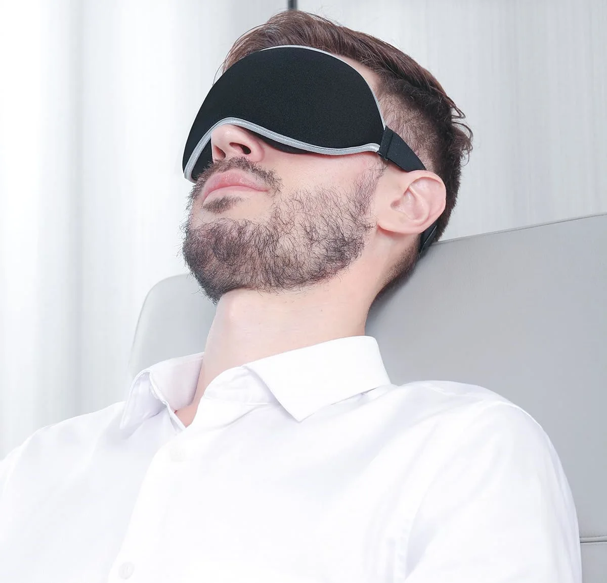 Leaning back in a chair in the black Spacious mask with its silver edge.